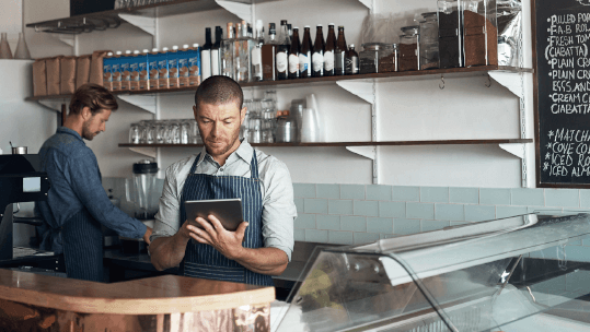 coffeeshop-owner-checking-his-tablet